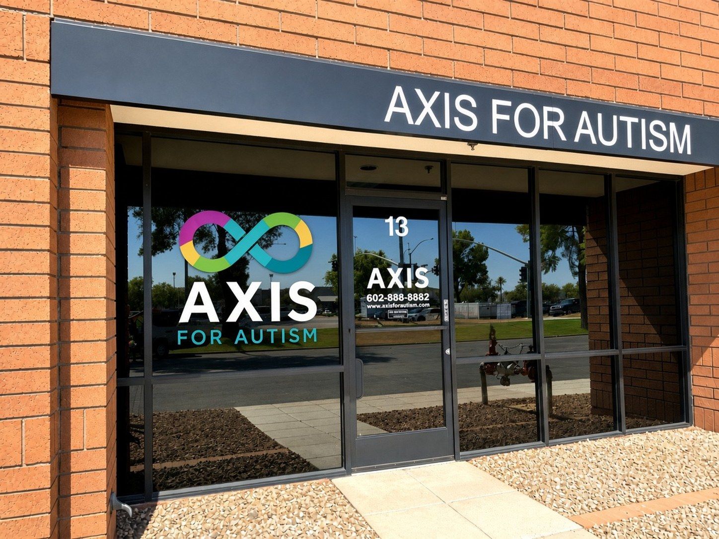 Exterior of the Axis for Autism Mesa clinic storefront with infinity logo on the window