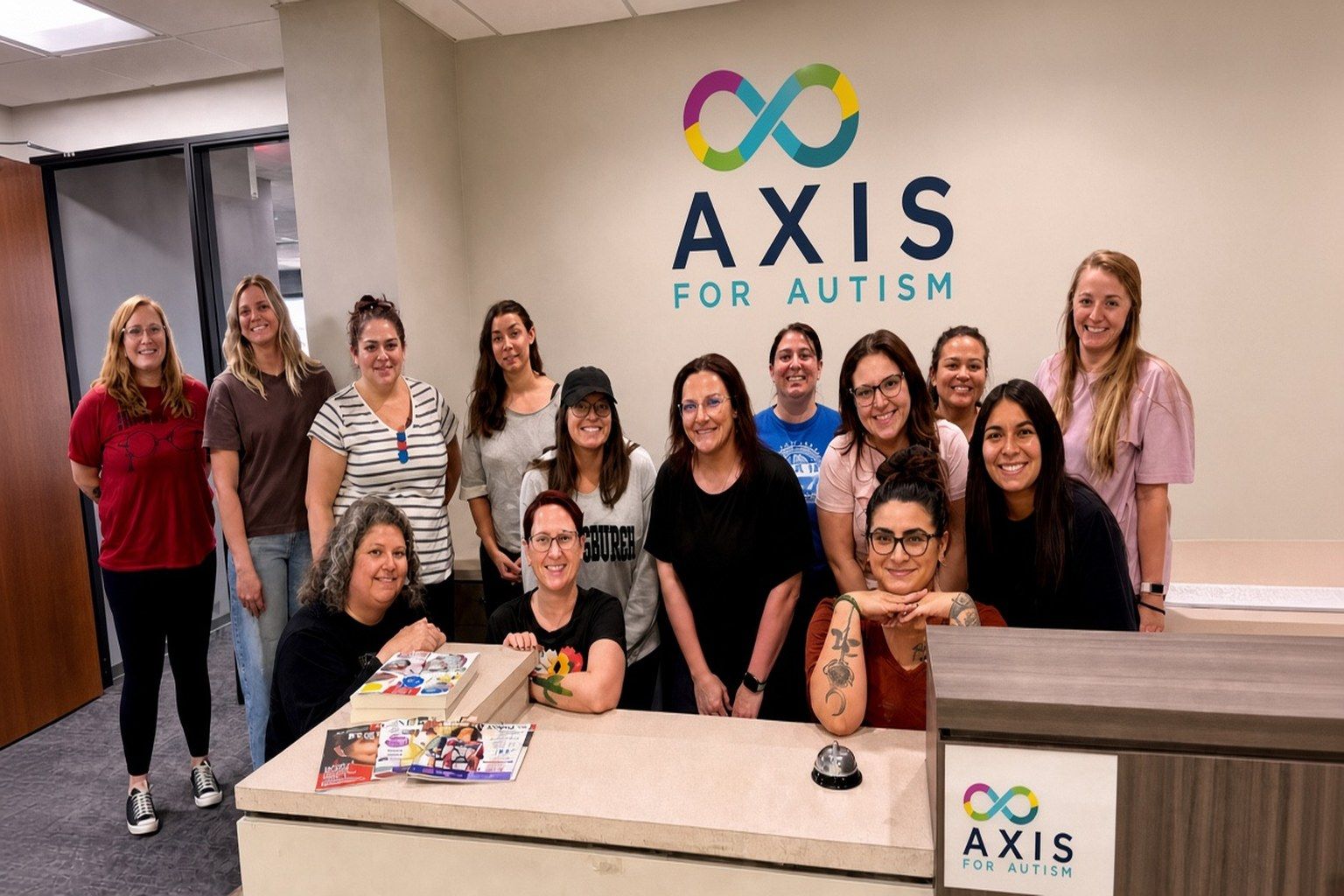 Axis for Autism team members smiling together in the clinic reception area