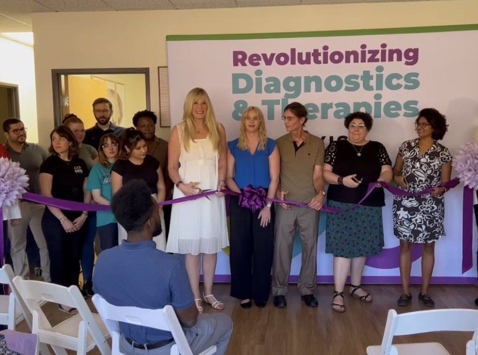 Axis for Autism staff and leaders cutting a purple ribbon at the opening of the first Axis clinic in March 2021
